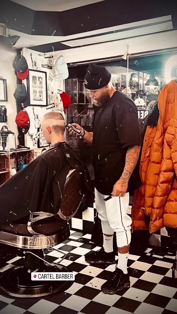 Barbier bei der Arbeit an einem Kunden im Cartel Barber Shop